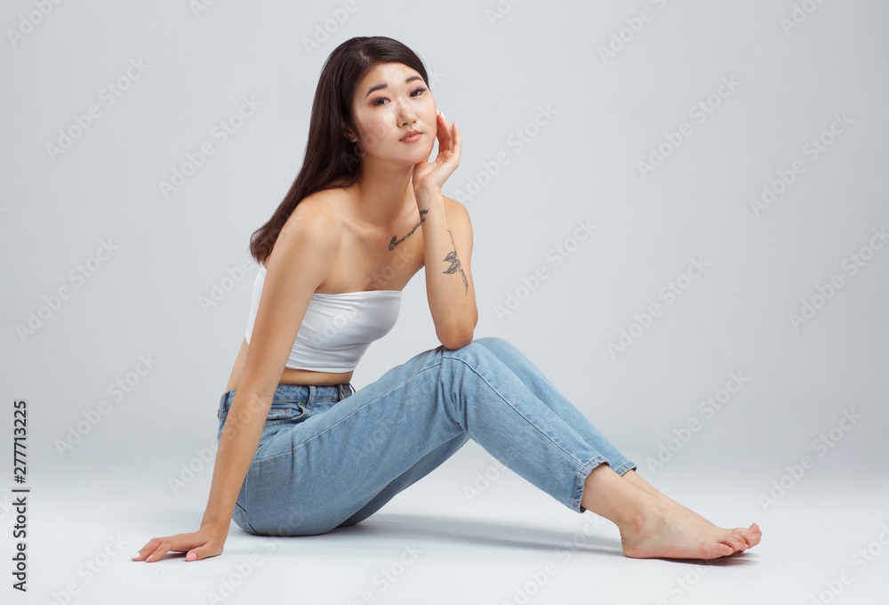 Beautiful young woman wearing white top and blue jeans