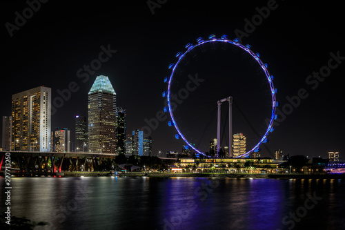 Singapur bei bei Nacht Skyline mit Wasser und Riesenrad