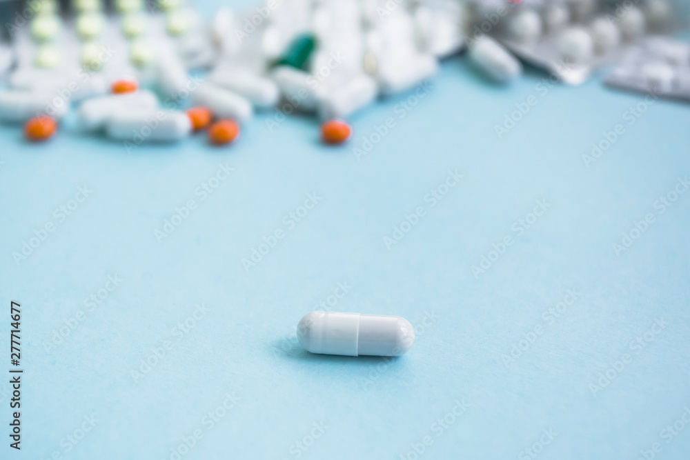 The most effective pill. The soothing capsules of drugs pills drugs tablets of different colors lie on a blue background. copy space. free space The most effective pill. The soothing capsules of drugs pills drugs tablets of different colors lie on a blue background. copy space. free space