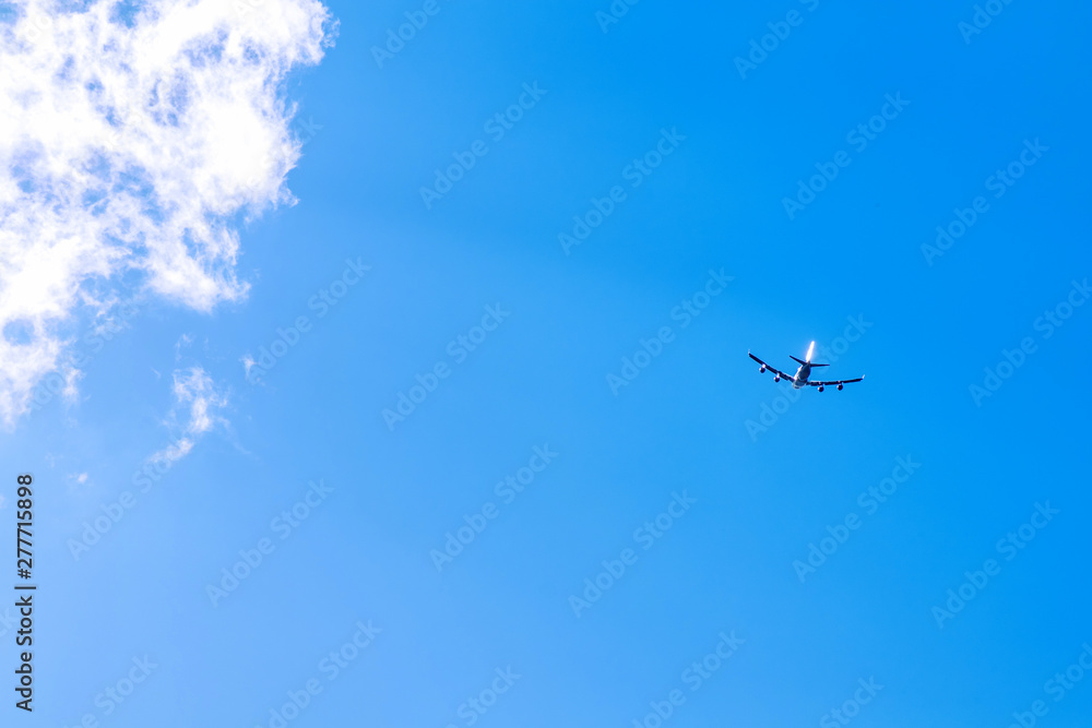 the silhouette of an airplane that flies against the blue sky and clouds the silhouette of an airplane that flies against the blue sky and clouds