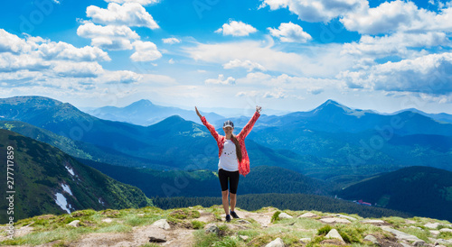 Happy hiker with her arms outstretched, freedom and happiness, achievement in mountains. Copy space