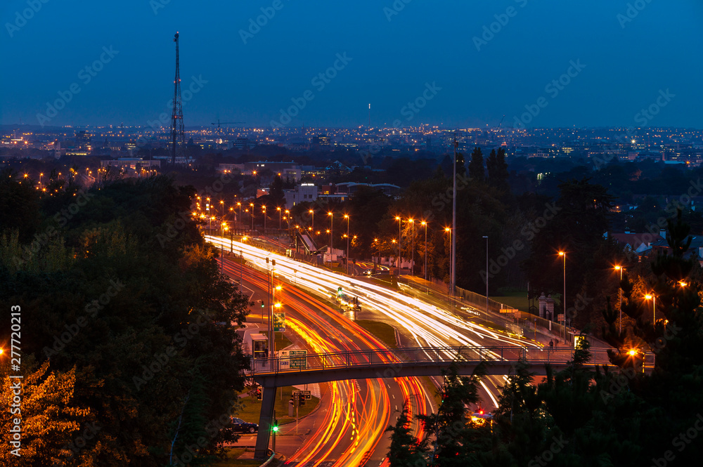 Traffic on a 4-lane road at dusk. Blurred streaks of headlights and red tail lights. Dublin, Ireland