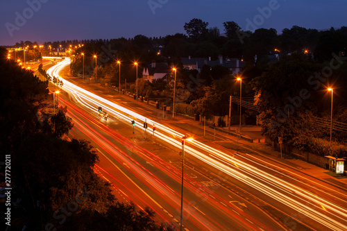 Traffic on a 4-lane road at dusk. Blurred streaks of headlights and red tail lights. Dublin, Ireland