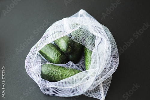 Reusable eco-friendly bag full of fresh seasonal cucumbers photo