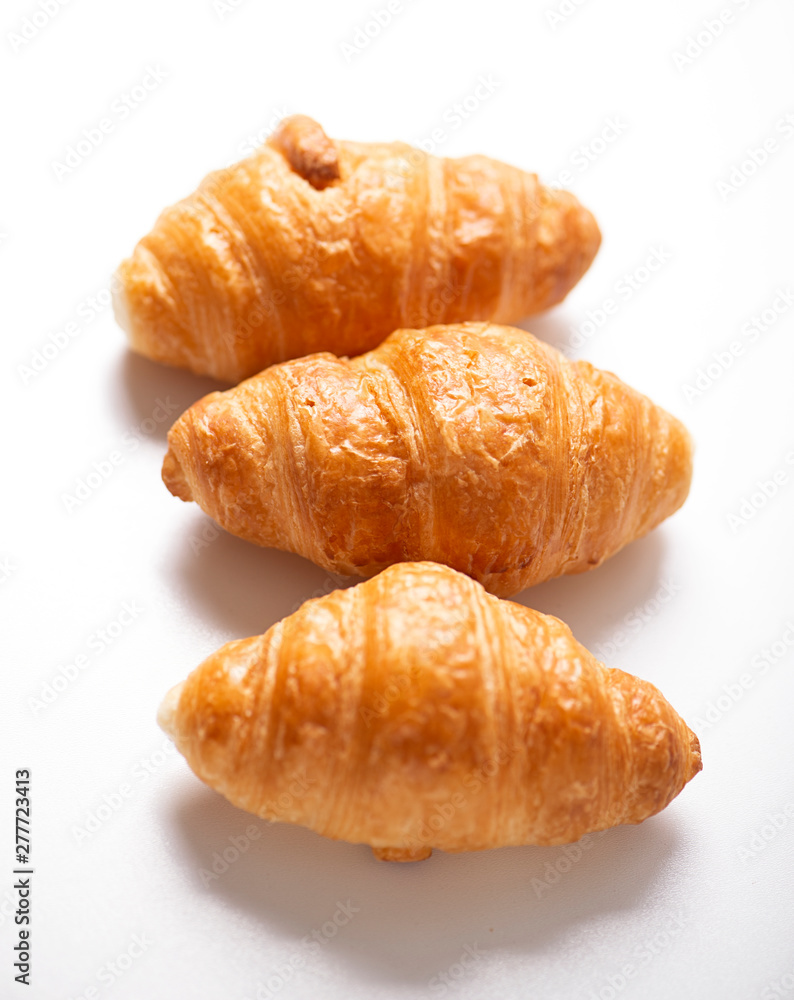Vertical shoot of three croissants on white background. Isolated.