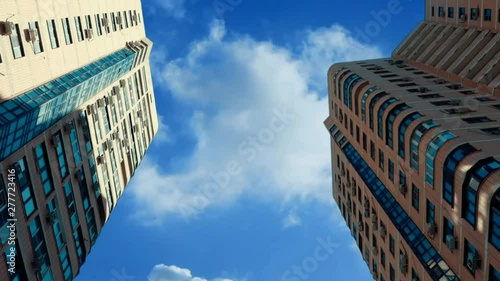Clouds float above the skyscrapers. Zoom out.