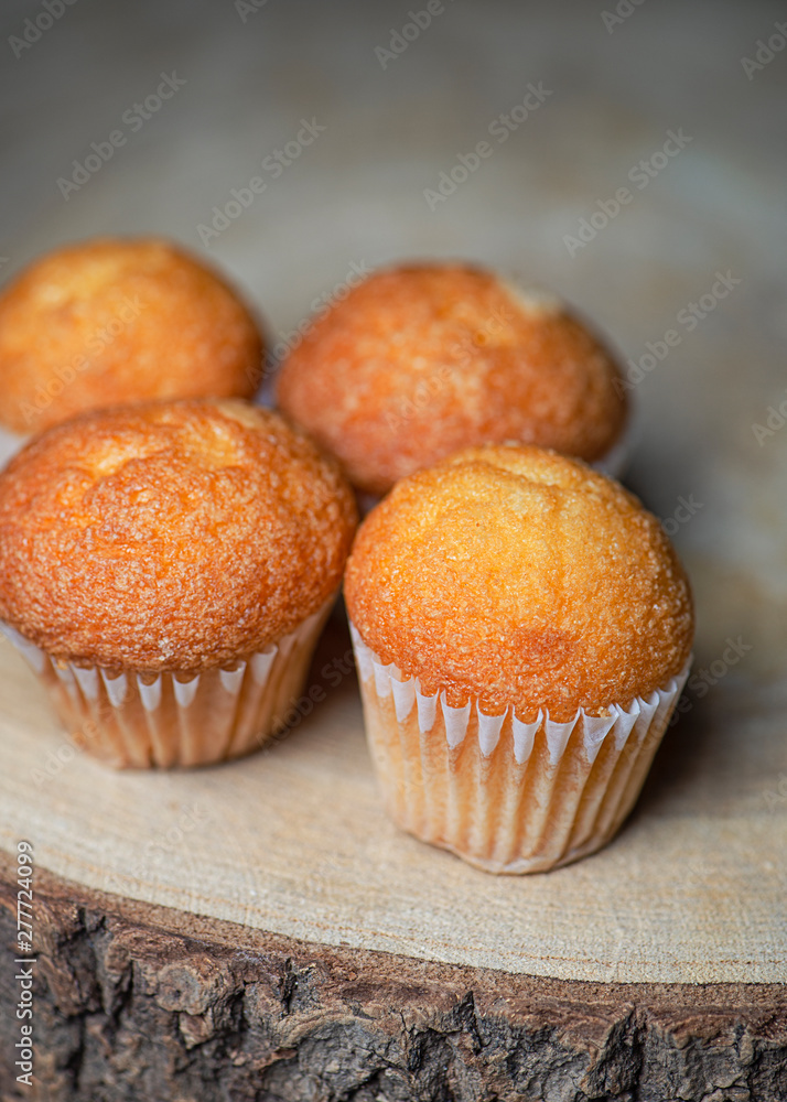 Close-up of cupcakes on wooden board. Sweets for breakfast. Vertical shoot. Close-up of cupcakes on wooden board. Sweets for breakfast. Vertical shoot.