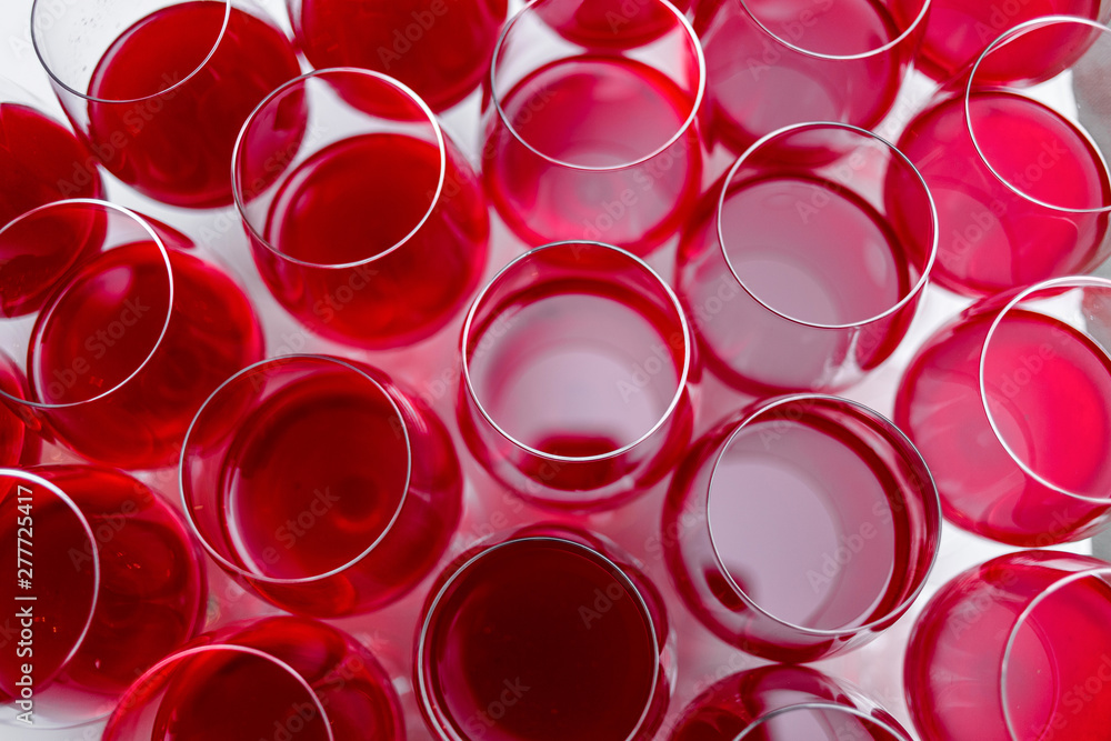 View from above at a a row of glasses filled with red wine are lined up ready to be served View from above at a a row of glasses filled with red wine are lined up ready to be served