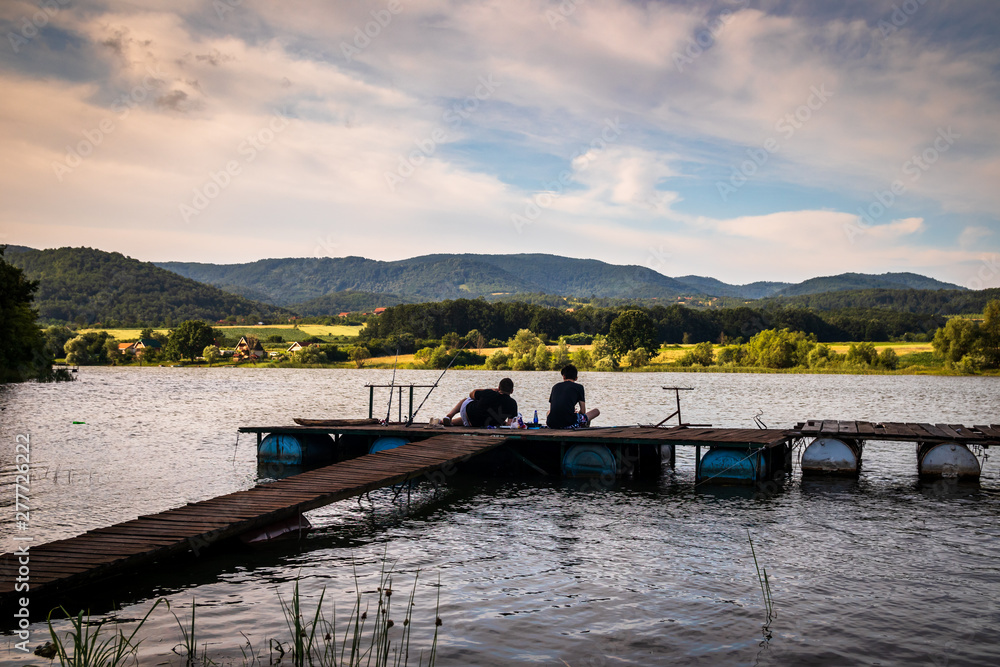 Fishermans on a primitive dock by the lake. Lake Gruza in the Serbia.