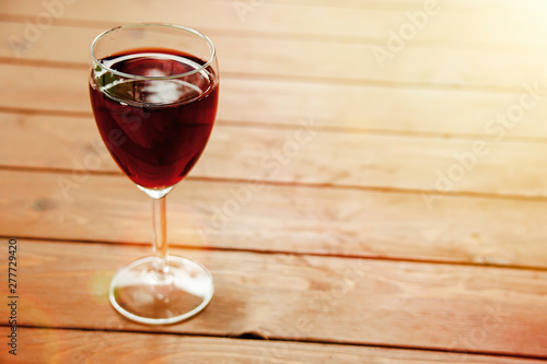 Glass of red wine on wooden table top view