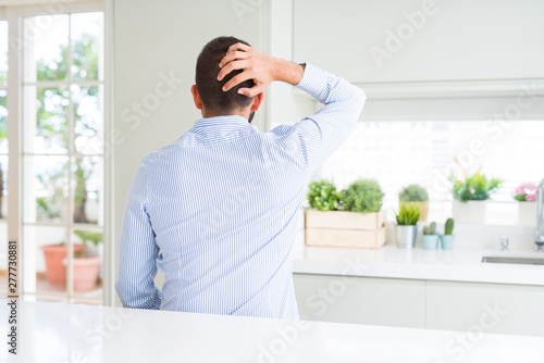 Handsome hispanic business man Backwards thinking about doubt with hand on head © Krakenimages.com