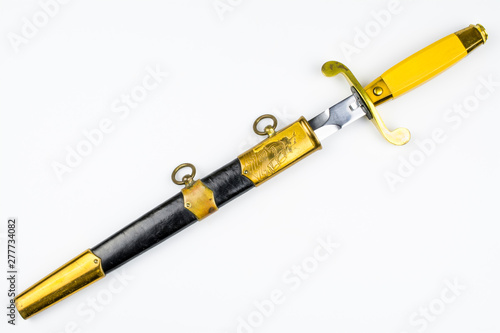 Photography Old dirk in black-yellow sheath isolated on a white background.