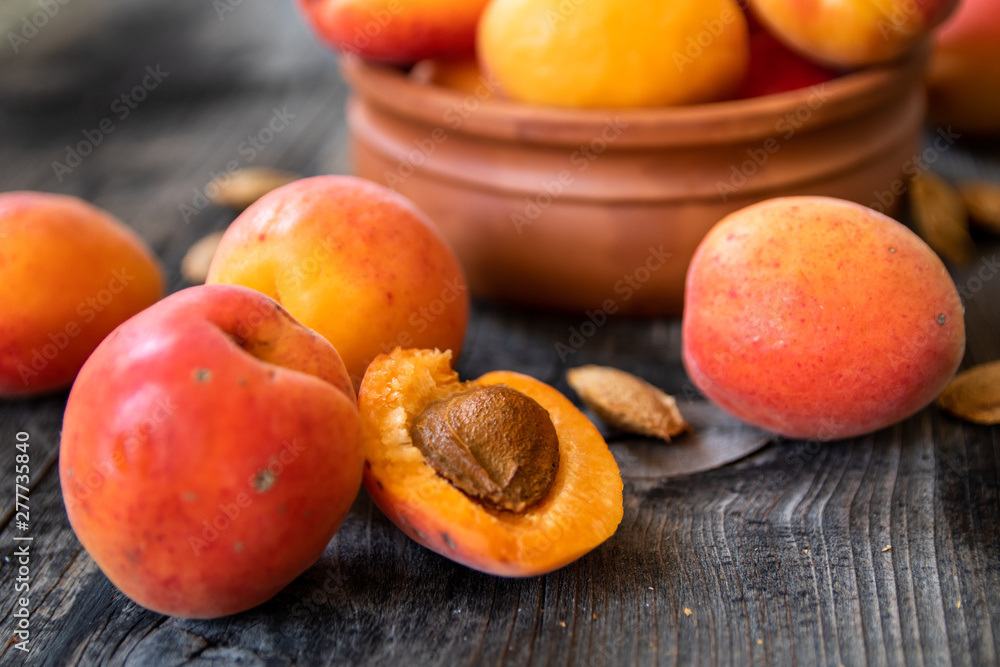 Fresh organic apricots in a clay bowl on old wooden table Fresh organic apricots in a clay bowl on old wooden table