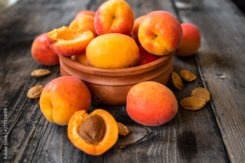 Photographie Fresh organic apricots in a clay bowl on old wooden table