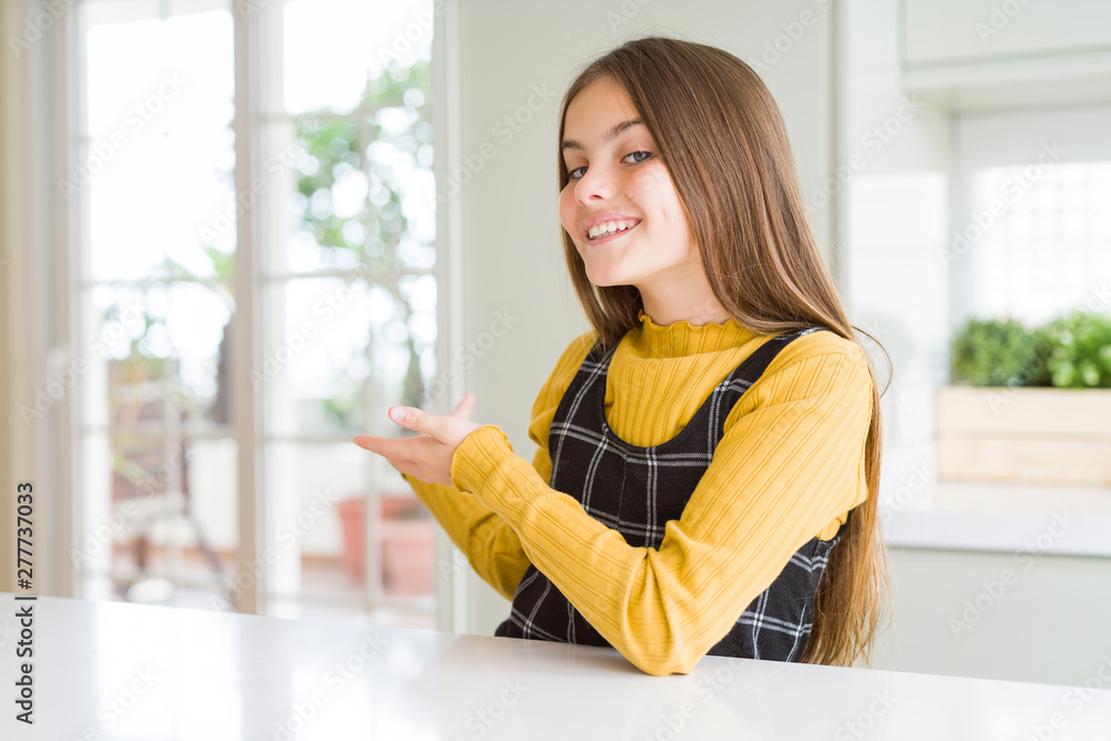Young beautiful blonde kid girl wearing casual yellow sweater at home Inviting to enter smiling natural with open hand Young beautiful blonde kid girl wearing casual yellow sweater at home Inviting to enter smiling natural with open hand