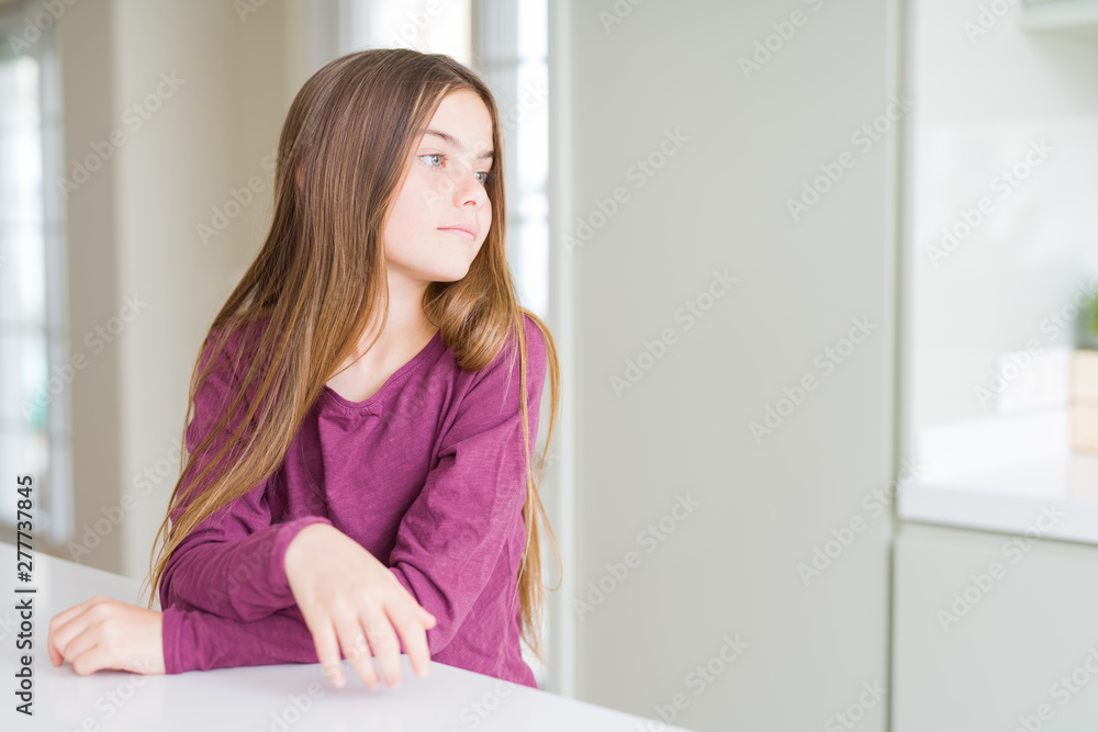 Beautiful young girl kid on white table looking to side, relax profile pose with natural face with confident smile. Beautiful young girl kid on white table looking to side, relax profile pose with natural face with confident smile.