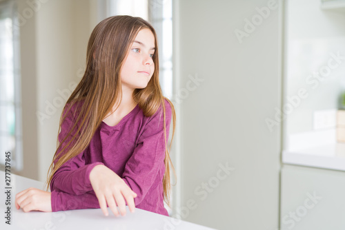 Beautiful young girl kid on white table looking to side, relax profile pose with natural face with confident smile. Free Download Beautiful young girl kid on white table looking to side, relax profile pose with natural face with confident smile. - GFXLoad