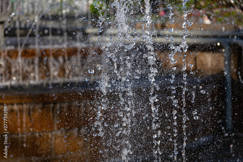 City fountain with splashes and jets of water hardened on a clear summer day