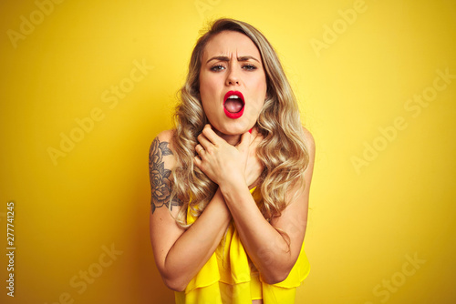 Young attactive woman wearing t-shirt standing over yellow isolated background shouting and suffocate because painful strangle. Health problem. Asphyxiate and suicide concept.