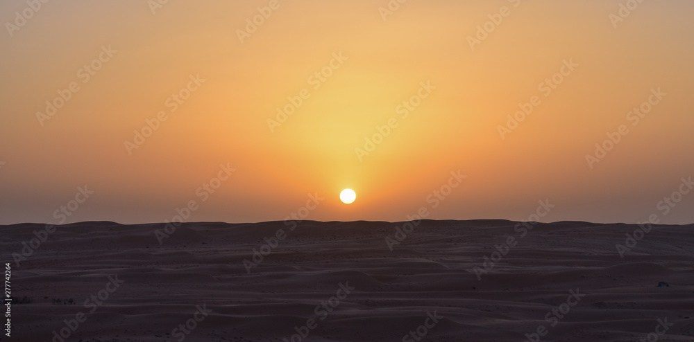 Anochecer en el desierto con el sol a punto de desaparecer