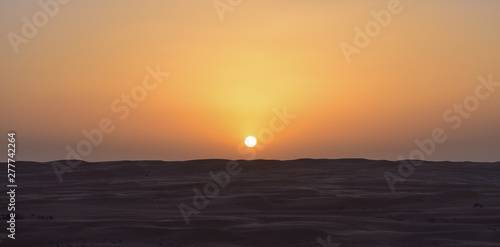 Anochecer en el desierto con el sol a punto de desaparecer