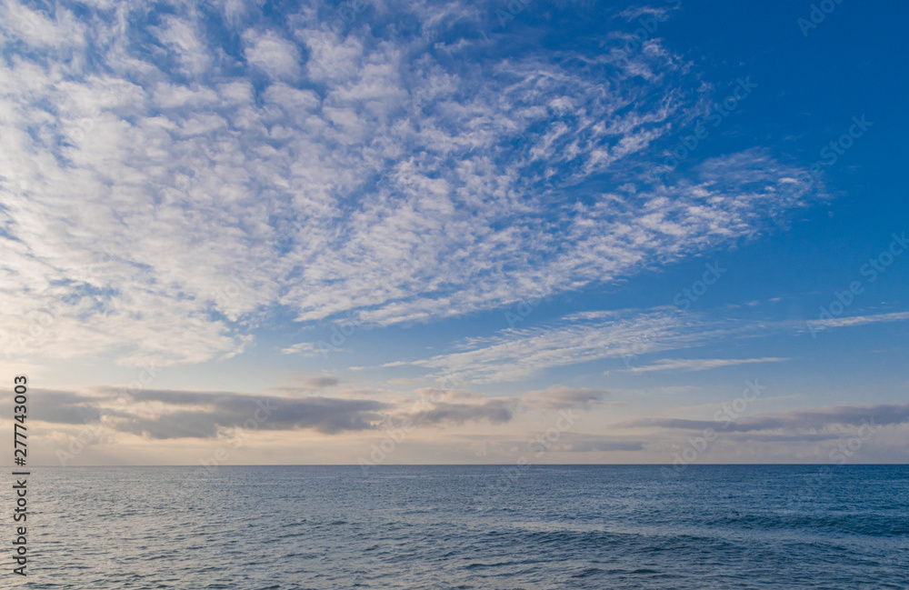 Photo landscape of the blue sky full of striking clouds over the calm sea - Horizon in the sea