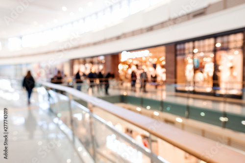 Blurred big sales on Black Friday. A long light floor in the mall with shops for buyers. Sale of clothing in a modern shopping center. The main background for the design. Shopping. Copyspace photo