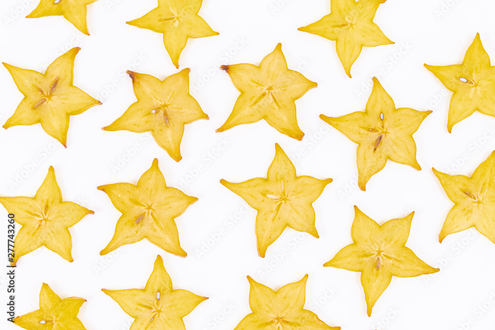 Close up of many slices of star fruit scattered on a white background - Averrhoa carambola Close up of many slices of star fruit scattered on a white background - Averrhoa carambola