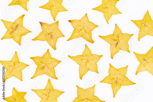 Close up of many slices of star fruit scattered on a white background - Averrhoa carambola