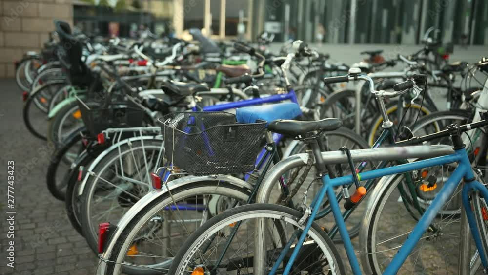 Bicycle parking in the city street. Group of bikes. Many vehicles are parked. The concept of ecology, sport and a healthy lifestyle. Prores, slow motion, close up Bicycle parking in the city street. Group of bikes. Many vehicles are parked. The concept of ecology, sport and a healthy lifestyle. Prores, slow motion, close up