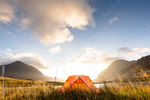 Llyn Idwal (lake), Snowdonia National Park, Bangor, Wales, United Kingdom: A tent at the lake in the early morning light just after sunrise. photo