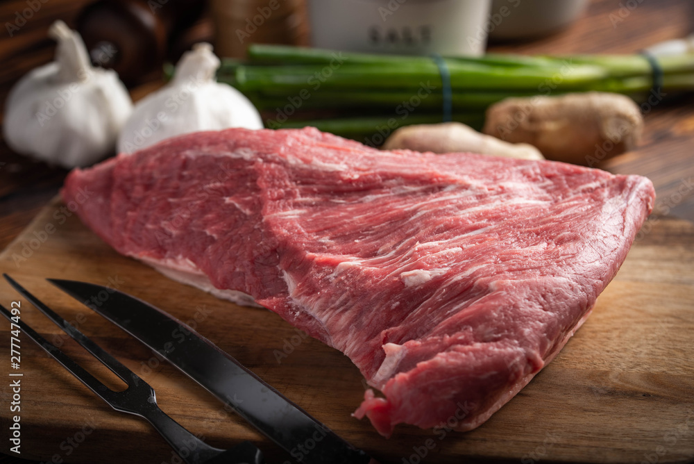 raw tri tip steak beef on wooden cutting board