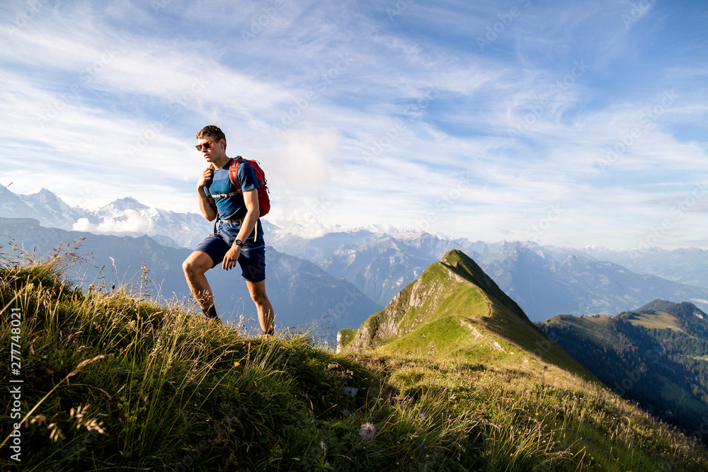 Hardergrat (ridge) hike above Lake Brienz, Canton of Bern, Switzerland: Hiking the Hardergrat from Interlaken town to the Brienzer Rothorn, which is an extreme hike covering about 27 kilomters and 3000 vertical meters. // A male hiker on the ridge that is Hardergrat. Hardergrat (ridge) hike above Lake Brienz, Canton of Bern, Switzerland: Hiking the Hardergrat from Interlaken town to the Brienzer Rothorn, which is an extreme hike covering about 27 kilomters and 3000 vertical meters. // A male hiker on the ridge that is Hardergrat.