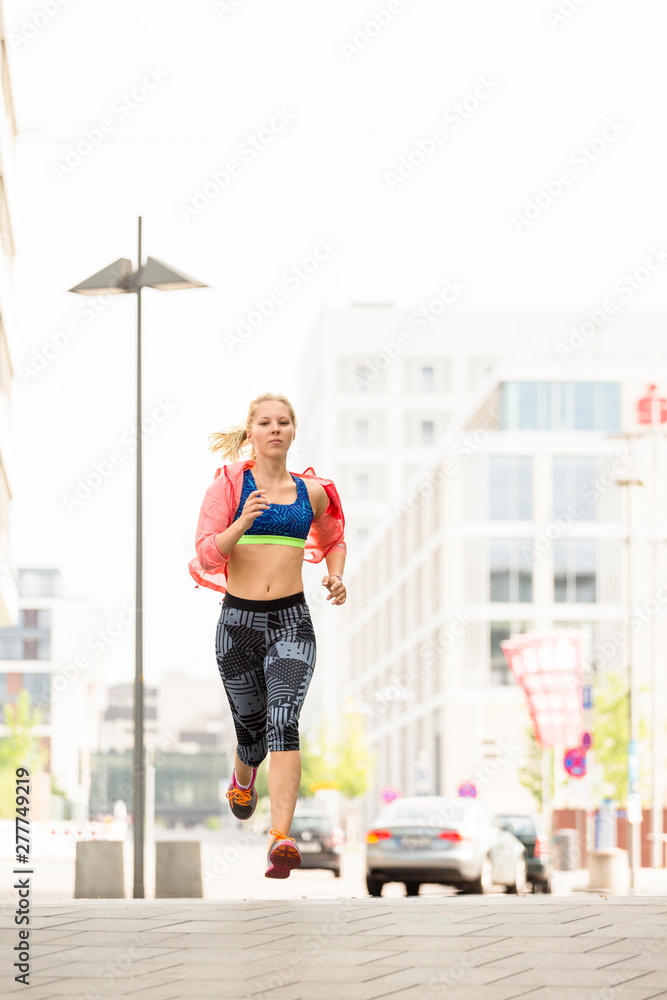 European Quarter, Stuttgart, Baden-W¸rttemberg, Germany: A female runner running through the city in the morning. European Quarter, Stuttgart, Baden-W¸rttemberg, Germany: A female runner running through the city in the morning.