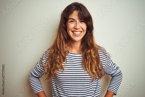 Young beautiful woman wearing stripes t-shirt over white isolated background with a happy and cool smile on face. Lucky person.