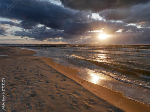 Morze zachód słońca - plaża fale i słońce