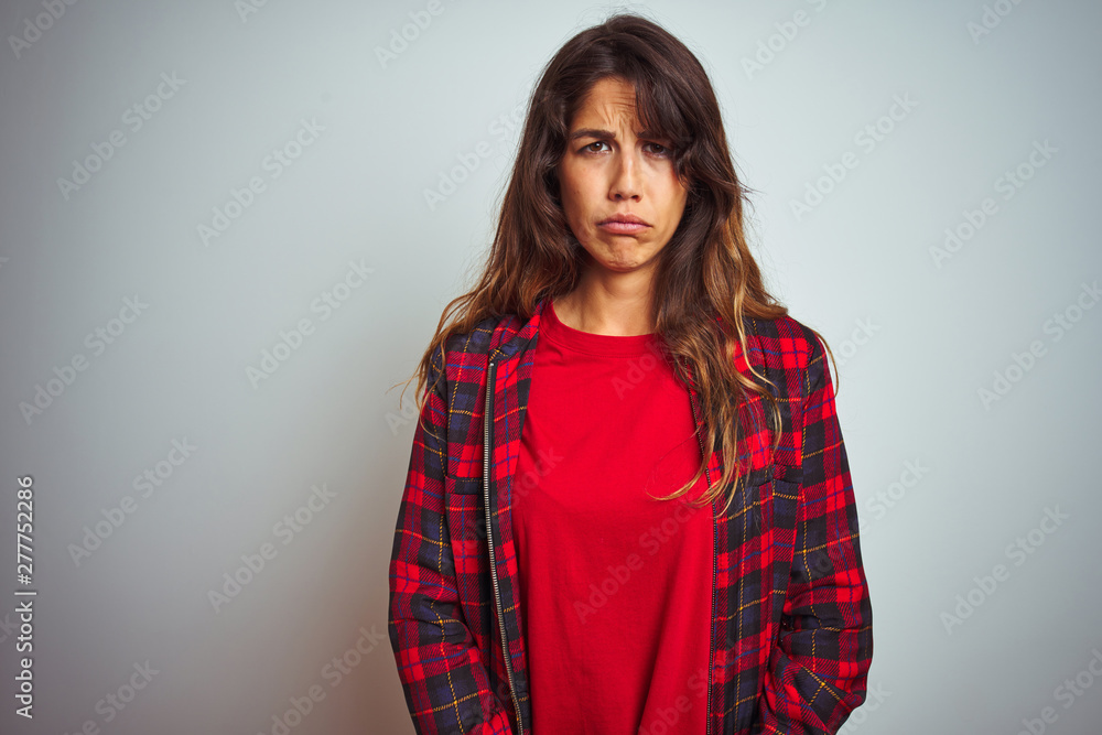 Young beautiful woman wearing red t-shirt and jacket standing over white isolated background depressed and worry for distress, crying angry and afraid. Sad expression. Young beautiful woman wearing red t-shirt and jacket standing over white isolated background depressed and worry for distress, crying angry and afraid. Sad expression.