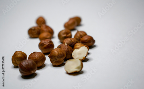 Several varieties of nuts are located on a white sheet of paper.