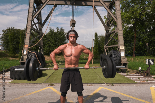 Black guy with barbell in outdoor gym photo