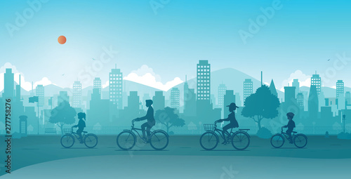 The family is riding a bicycle in a city park.