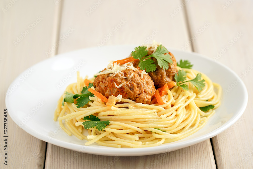 meatballs with pasta on a white plate on a background of white boards. Delicious Meat Balls Decorated with Herbs meatballs with pasta on a white plate on a background of white boards. Delicious Meat Balls Decorated with Herbs
