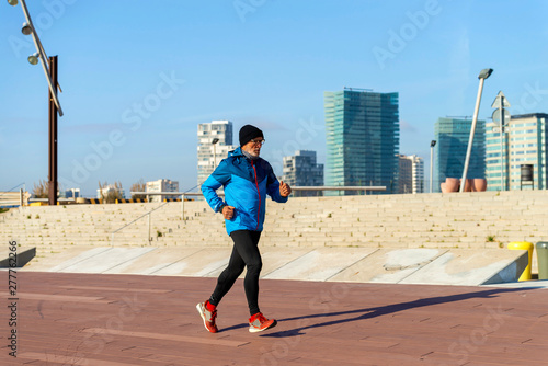Full length of senior man jogging while exercising at park in winter