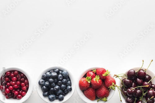 top view of sweet cranberries and blueberries  strawberries and cherries on bowls