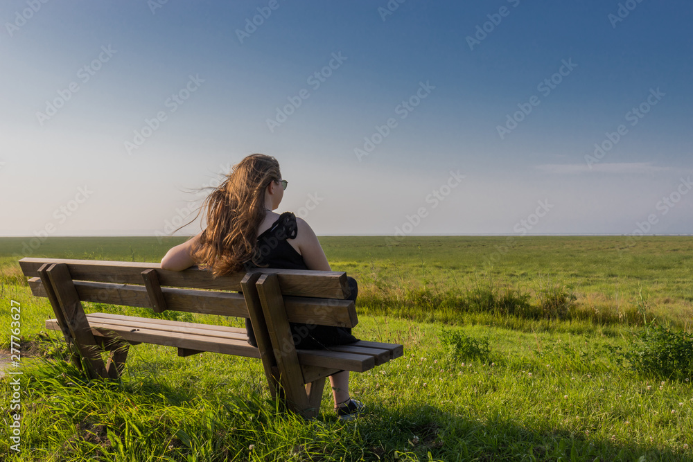 blonde girl sitting on a bench