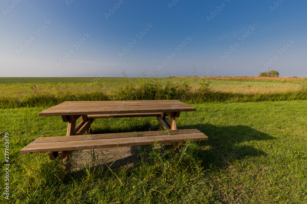 a bench with table in a meadow