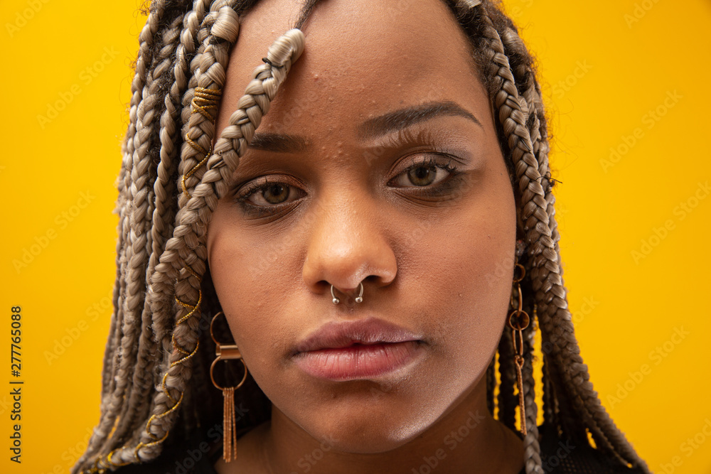 Beautiful young african american woman with dread hair on yellow background Beautiful young african american woman with dread hair on yellow background