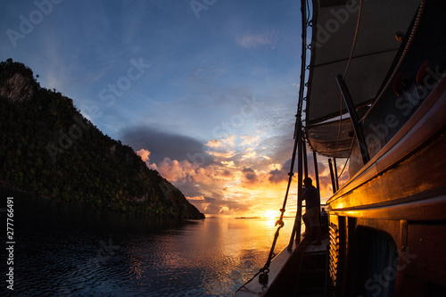 A gorgeous sunset occurs among the rugged limestone islands of Raja Ampat, Indonesia. This tropical region, part of the Coral Triangle, is known for its incredible marine biodiversity.