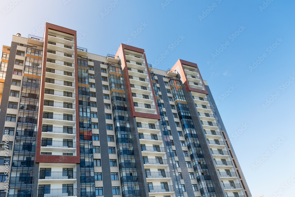 View of public park with newly built modern block of flats under blue sky with few clouds