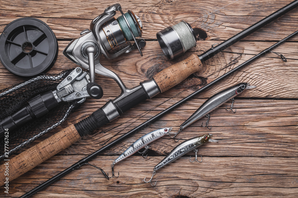 Fishing tackle for catching predatory fish. Wobblers, spinning, reel,  fishing line on the wooden background Stock Photo