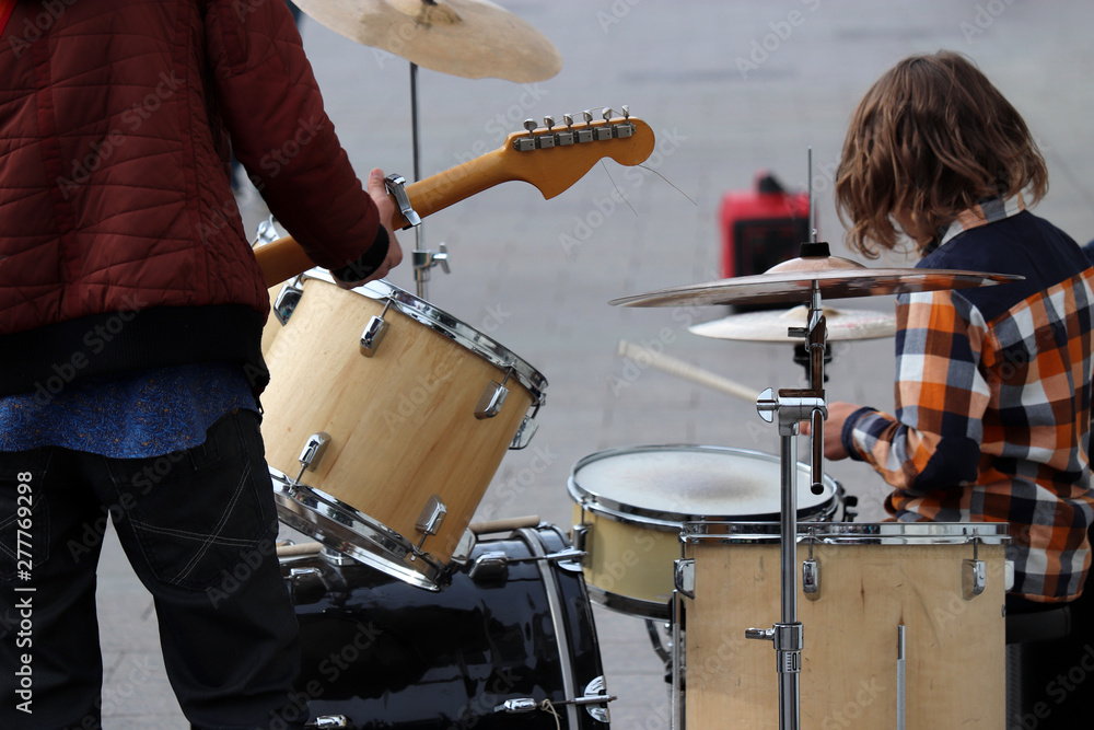 Street musicians play guitar and drums. Concert in a city, urban performers outdoor Street musicians play guitar and drums. Concert in a city, urban performers outdoor